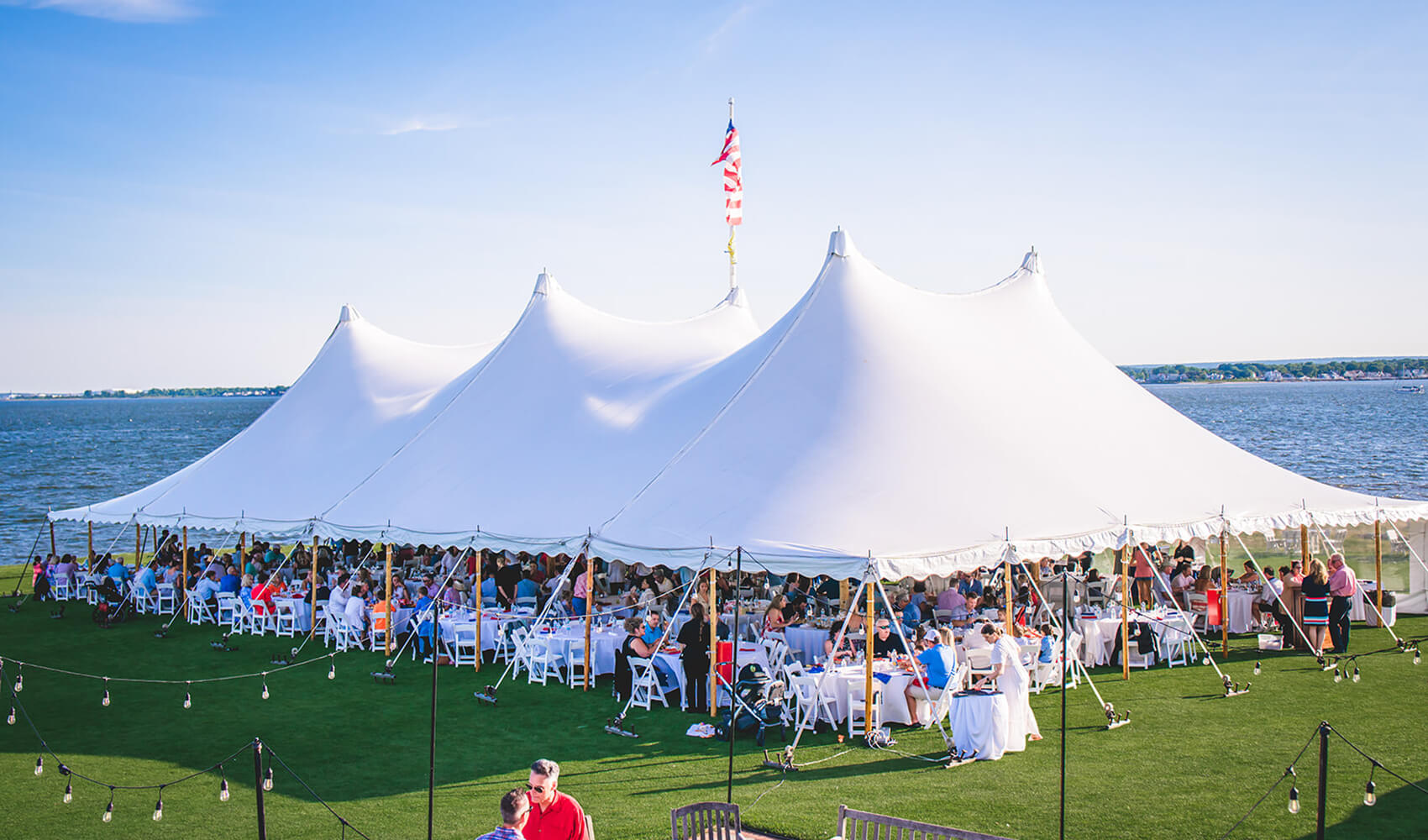 outdoor social event under large white tent